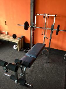 a gym with a bench and other equipment at HOSTEL 66 Bremerhaven Geestland in Imsum