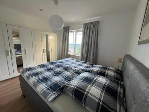 a bedroom with a bed with a plaid blanket on it at Wohnung mit schönem Aussicht in Bendorf