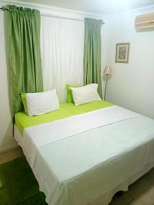 a bedroom with a large bed with green curtains at The Royal at winchester in Kingston