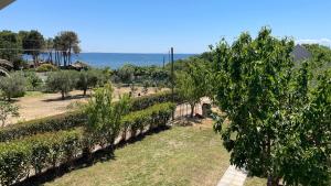 a garden with trees and the ocean in the background at Sunset Hideaway by GG in Mákri