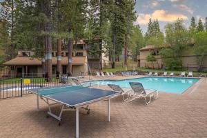 a ping pong table and chairs in front of a pool at Corwin's Quarters in Kings Beach