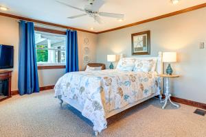 a bedroom with a bed with blue curtains and a tv at Great Lake Erie Getaway with Hot Tub and Private Beach in Avalon Beach