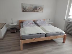 a bed in a room with two tables at Schwandorf22 in Bretten