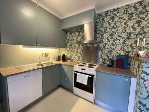a kitchen with blue cabinets and a white stove top oven at Jugend 1902 in Ålesund