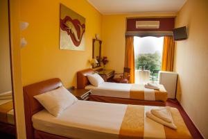 a hotel room with two beds and a window at Galini Palace in Athens