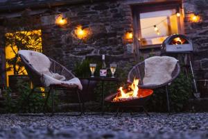 LiftonにあるThe Yard at Borough Farmの建物前の椅子2脚と火炉