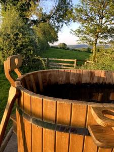 LiftonにあるThe Yard at Borough Farmの木製のベンチの隣に置かれた木製の樽