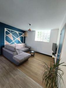 ein Wohnzimmer mit Sofa und Fernseher in der Unterkunft Le Caladou ! T3 classé 3 étoiles - Centre ville in Espalion