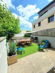 eine Terrasse mit einem Tisch und Stühlen auf einem Rasen in der Unterkunft Le Caladou ! T3 classé 3 étoiles - Centre ville in Espalion