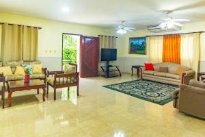 a living room with couches and chairs and a table at Villa Infinito Bani's Exclusive Beachside Mansion in Baní