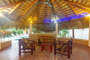 a patio with chairs and a table and a roof at Villa Infinito Bani's Exclusive Beachside Mansion in Baní