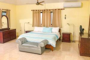 a bedroom with a bed and a chair in it at Villa Infinito Bani's Exclusive Beachside Mansion in Baní +46 photos