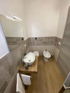 un bagno con lavandino, water e specchio di LaPignaapartments a Marsala Altre 11 foto