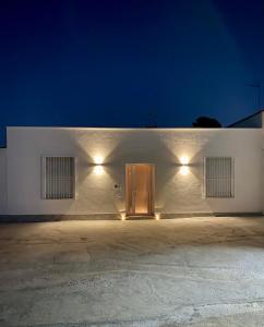 una porta in un edificio bianco con luci accese di LaPignaapartments a Marsala