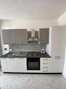 una cucina bianca con fornelli e lavello di LaPignaapartments a Marsala