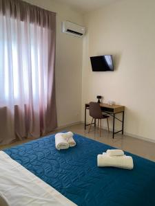 una camera da letto con un letto con asciugamani sopra di LaPignaapartments a Marsala