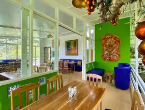 a restaurant with green walls and a wooden table and chairs at Nan La Tigra in El Rosario
