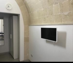 a flat screen tv on a wall in a room at La Casaredda Guesthouse, 69-71 in Grottaglie
