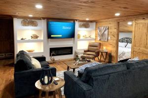 a living room with two couches and a flat screen tv at Driftwood House in Mead