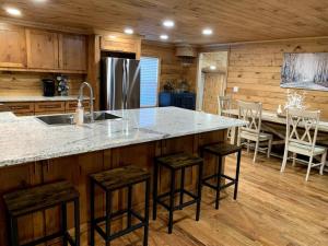 a kitchen with a large counter with stools and a sink at Driftwood House in Mead