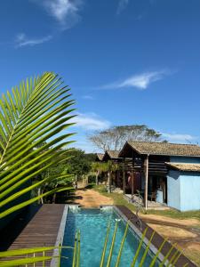 a swimming pool in front of a house at Rosatrip Surf Bungalows in Praia do Rosa