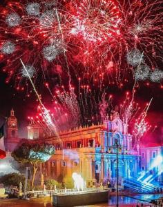 un espectáculo de fuegos artificiales frente a un edificio en Martiry Suite Apartment, en Catania