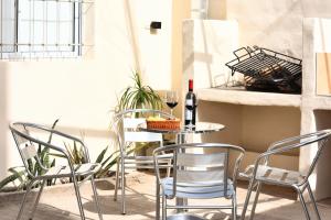 a table with chairs and a bottle of wine on it at Departamentos Valle de los Andes in San Rafael