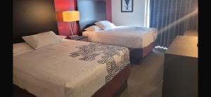 a hotel room with two beds and a lamp at Americas Best Value Inn Horseheads in Elmira
