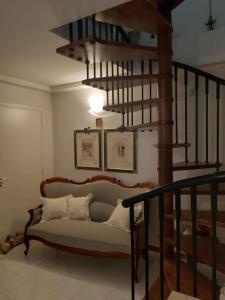 sala de estar con sofá y escalera de caracol en La casa di Gaga - Appartamento nel Chianti senese, en Ponte A Bozzone