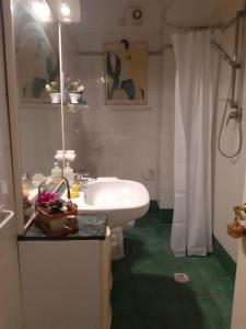 Un baño con lavabo blanco y ducha. en La casa di Gaga - Appartamento nel Chianti senese, en Ponte A Bozzone