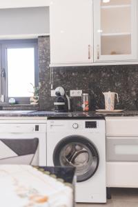 a white kitchen with a washing machine in it at Vivenda à Beira Rio in Folgosa +71 photos
