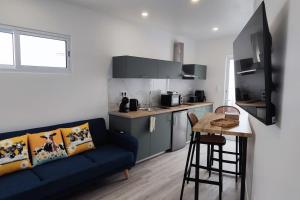 ein Wohnzimmer mit einer blauen Couch und eine Küche in der Unterkunft Azure Loft in Mosteiros