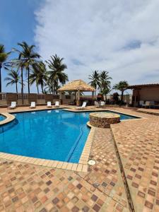ein Swimmingpool mit Palmen im Hintergrund in der Unterkunft Apartamento con vista al Mar y salida a la playa in Tucacas