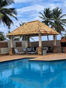 ein großer Sonnenschirm neben einem Swimmingpool in der Unterkunft Apartamento con vista al Mar y salida a la playa in Tucacas
