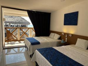 a hotel room with two beds and a balcony at Hotel Paseo del Sol in La Paz