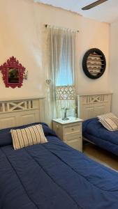 a bedroom with two beds with blue sheets and a window at Casa Antigua in San Francisco +24 photos