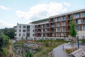 an apartment building with a garden in front of it at Novostavba v centre + parking in Banská Bystrica