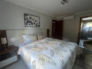 a bedroom with a bed with a white comforter at Venda Nova Apart in Venda Nova do Imigrante