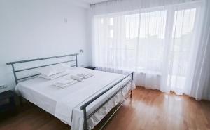 a bedroom with a bed with white sheets and a window at Portofino Villa in Costinesti +39 photos