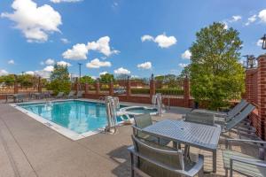 a swimming pool with chairs and a table and a picnic table at Best Western Plus Duncanville Dallas in Duncanville