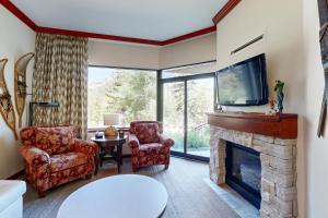 a living room with a fireplace and a tv at Resort at Squaw Creek's 128 in Olympic Valley