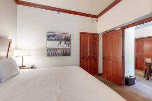 a bedroom with a white bed and wooden doors at Resort at Squaw Creek's 128 in Olympic Valley +31 photos