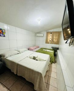 a room with two beds in a room at Pousada do Gord0 in Bonito