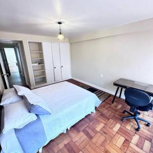 a bedroom with a bed and a desk and a chair at Amplio Departamento con terraza in Concepción