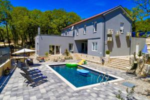 a house with a swimming pool in front of it at Luxury Villa Andrea Vrzika in forest near the sea with heated pool in Zagvozd