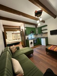 a living room with a green couch and a kitchen at Saint Johns Hill Boutique Ephesus in Selçuk