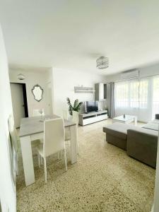 a white living room with a table and a bed at Apartamento Las Niñas in Nerja +18 photos