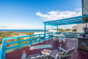 a deck with a table and chairs and the ocean at Blue View - UNINTERRUPTED OCEAN VIEWS FOR MILES in Guilderton