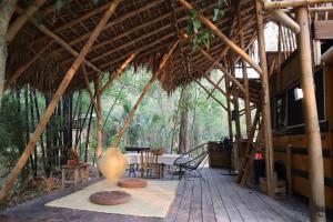 a large straw hut with a table and chairs in it at Caravana junto al río en la huasteca potosina in Aquismón