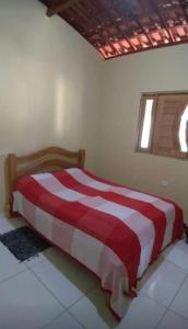 a bedroom with a red and white bed in a room at Casa na Serra in Bezerros